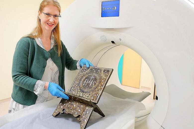 Ms Birte Koehler, a senior object conservator at the Heritage Conservation Centre, with a centuries-old wooden book stand that underwent a CT scan at the Singapore General Hospital yesterday.