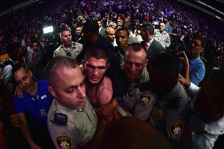 Above: Khabib Nurmagomedov's choke on Conor McGregor saw the Irishman tap out in the fourth round. Left: Nurmagomedov is escorted out of the arena. He is expected to be heavily disciplined by the Nevada State Athletic Commission, which is withholding