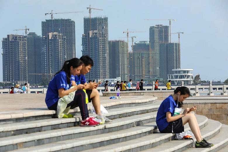 Residential buildings under construction in Haikou in China's Hainan province. Home buyers angry that apartments are being sold for much less than what they paid swarmed property developers' marketing offices across the country over the Golden Week h