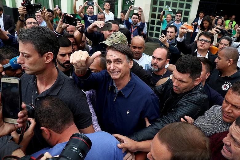 Mr Jair Bolsonaro of the Social Liberal Party gesturing on Sunday after casting his vote in Rio de Janeiro. He has portrayed himself as the only candidate untainted by corruption.
