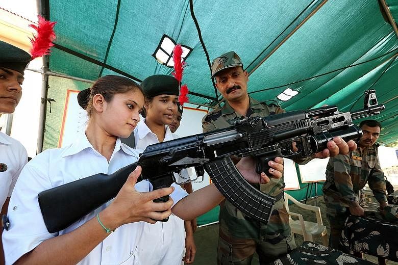 An Indian army soldier explaining how an AK-47 assault rifle works to National Cadet Corps members during Parakram Parv celebrations in the central Indian city of Bhopal on Sept 29. The celebrations mark the second anniversary of an attack by the Ind