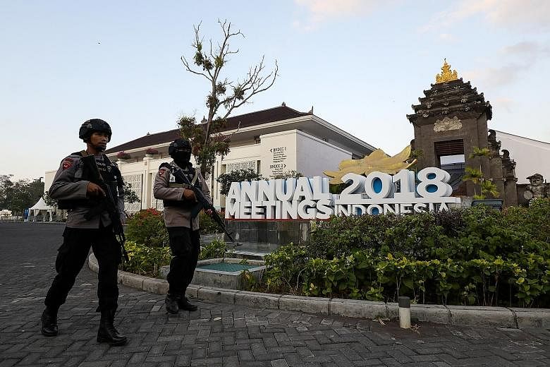 Police officers patrolling outside the venue of the International Monetary Fund-World Bank annual meetings in Nusa Dua, Bali, yesterday. While evidence of the impact of a trade war on economic momentum is, as yet, hard to detect, trade frictions rema