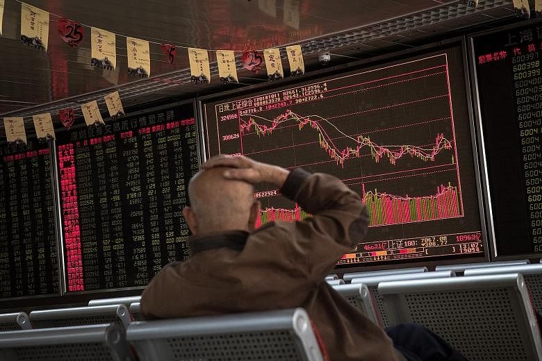 A man watching an electronic board showing the stock index and prices at a securities brokerage in Beijing yesterday. Stock markets across Asia plunged after the Dow Jones fell more than 800 points.