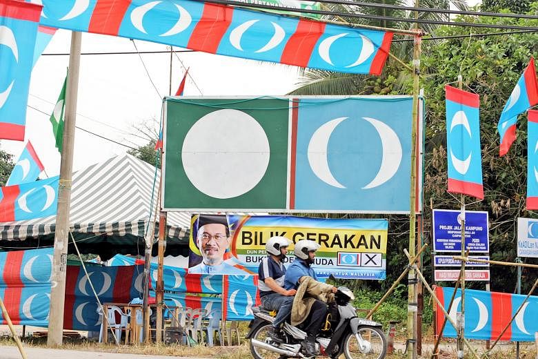 The logos of Parti Keadilan Rakyat (PKR) and Parti Islam SeMalaysia (in green) amid a sea of PKR banners in Kampung Permatang Pasir in Permatang Pauh, a former constituency of PKR leader Anwar Ibrahim. He will run tomorrow in the Port Dickson by-elec