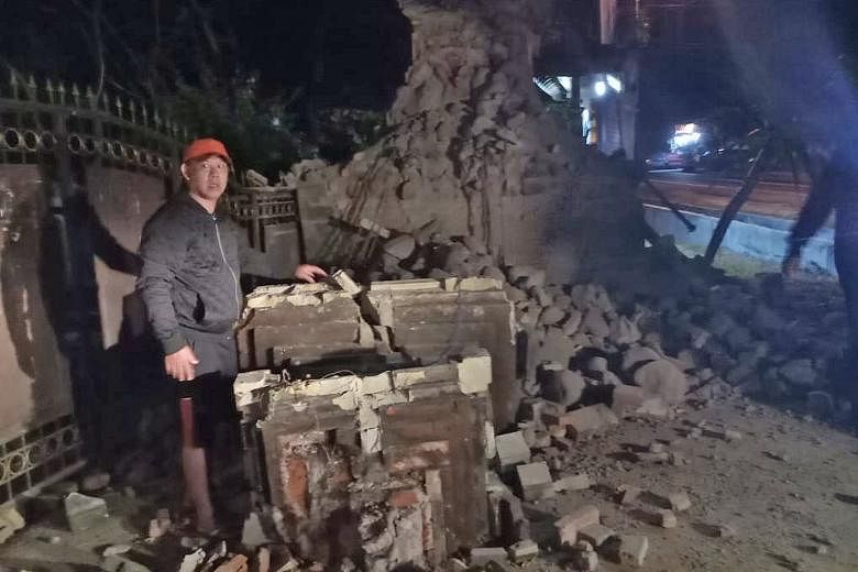 A photo provided by the Indonesian disaster management agency showing a man at a damaged building in Sumenep regency, East Java, yesterday. The epicentre of the quake was 55km north-east of East Java.