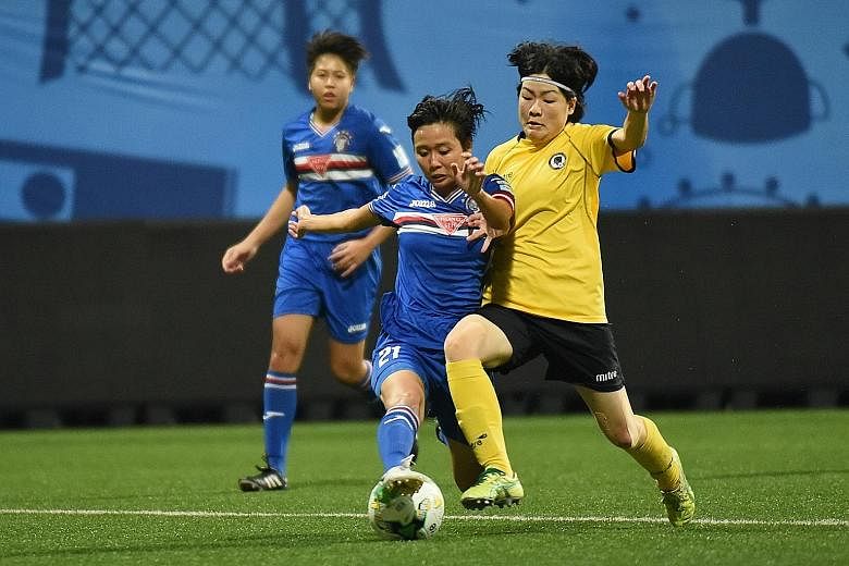 Warriors FC's Nur Izyani and Tanjong Pagar's Yuki Monden tussling for the ball during the Football Association of Singapore (FAS) Women's Challenge Cup final at Jalan Besar Stadium yesterday. Warriors retained their title with a 6-0 victory. In the t