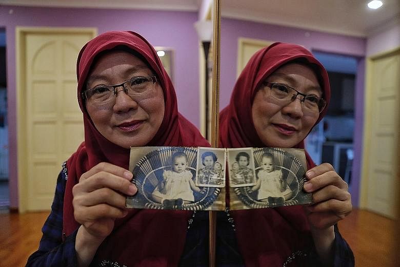 Madam Zahara Abdullah with her baby photos, including one taken with her late adoptive mother Habsah Masagos Omar. She also has adoption documents and her birth certificate, but they do not carry her birth parents' names.