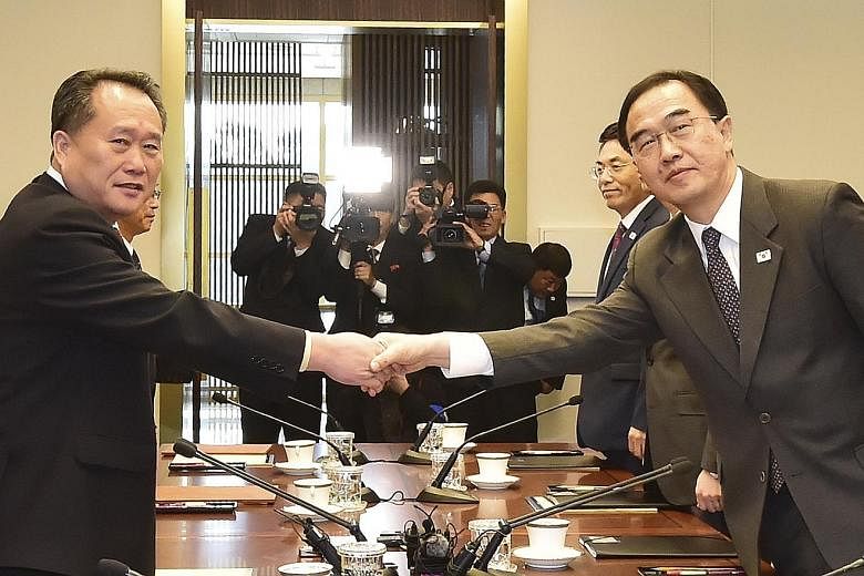 South Korean Unification Minister Cho Myoung-gyon (wearing glasses) and North Korea's Committee for Peaceful Reunification chairman Ri Son Gwon shaking hands prior to their talks in Panmunjom yesterday.