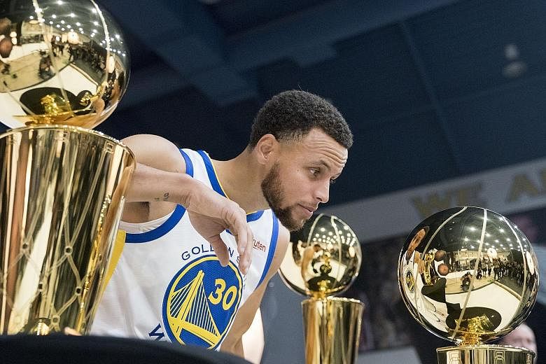 Golden State Warriors' star guard Stephen Curry in a pensive mood as he looks at the team's championship trophies during a media day at Rakuten Performance Centre last month.