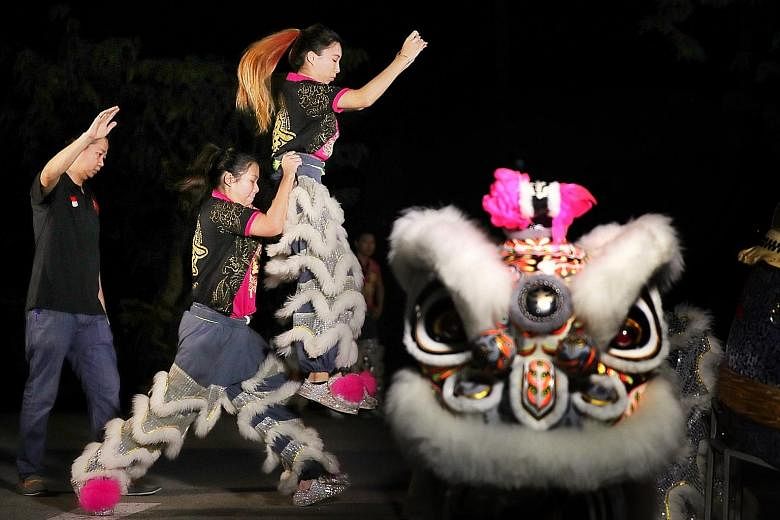 Shi Long Dragon and Lion Cultural Troupe member Stella Chua, 27, holding up teammate Leow Hui Zhi, 21, as they warm up for a practice under the watchful eyes of their coach Jason Choong, 39.