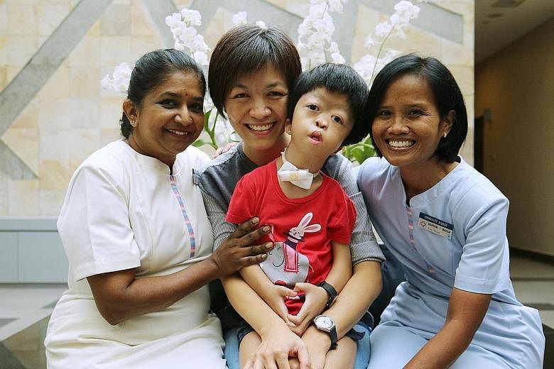 Ms Lee Seu Hong and her daughter Kang En Ning with KKH's assistant nurse clinician Selvi Thevathas and nurse clinician Maryani Abdul Wahab. Ms Lee stopped working in advertising to care for her daughter, who has Antley Bixler syndrome.