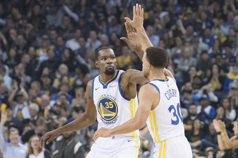 Golden State Warriors' Kevin Durant congratulating his teammate Stephen Curry for nailing a three-pointer during their 108-100 opening win over the Oklahoma City Thunder.