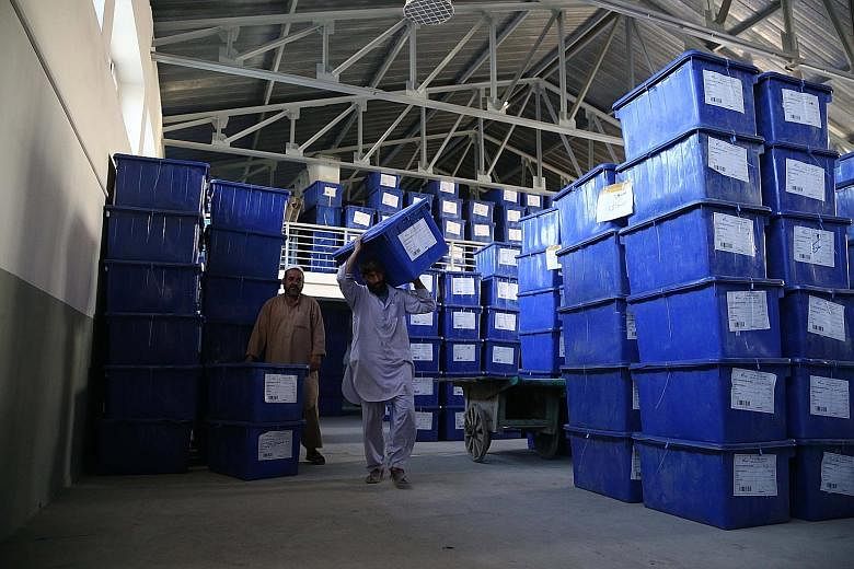 Employees of the Independent Election Commission carrying ballot boxes ahead of today's polls in Afghanistan. There are concerns over vote-rigging because there is no functioning population database in the country.