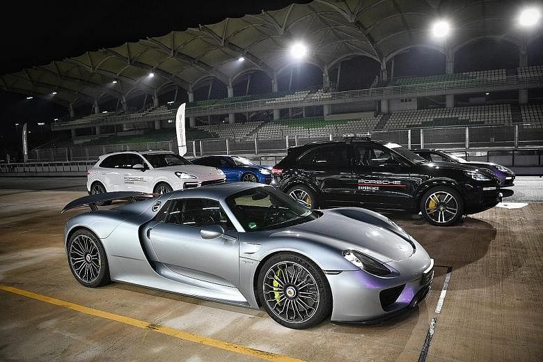 The line-up of hybrid cars at Porsche's E-Performance Nights at the Sepang track includes the 918 Spyder (foreground), Panamera Turbo S E-Hybrid (in black and white) and Cayenne E-Hybrid.