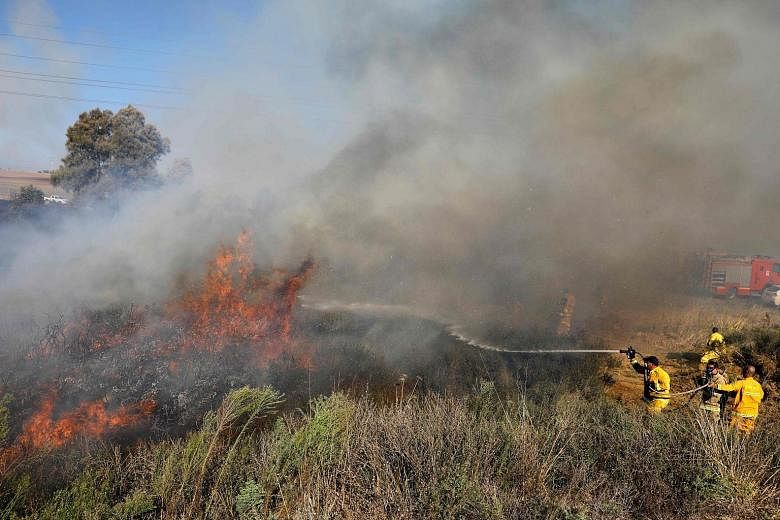 Israeli firefighters trying to extinguish a fire in a forest near the city of Sderot, along the border with the Gaza Strip, on July 31. The fire was caused by inflammable material attached to a balloon that was launched by Palestinian protesters from