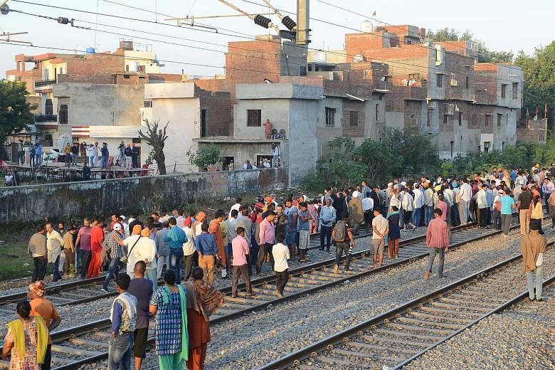 Grieving relatives and residents scouring the accident site yesterday, some looking for the belongings of their loved ones, after a train ran over revellers gathered on the railway tracks for a festival in Amritsar last Friday. Protesters called for 
