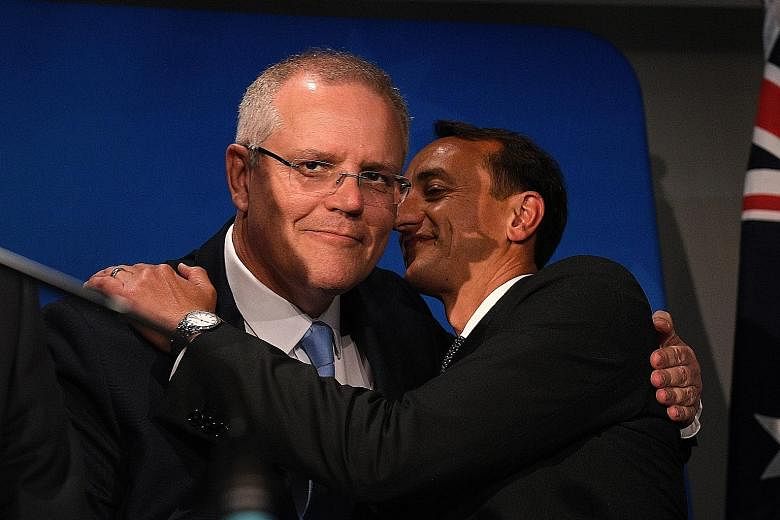 Australian Prime Minister Scott Morrison (left) embracing Liberal candidate Dave Sharma before his concession speech, at the Liberal Party's Wentworth by-election function in Double Bay, Sydney, yesterday.