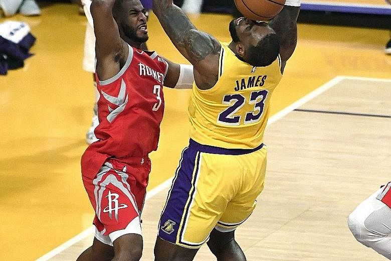 The Lakers' LeBron James (No. 23) is fouled by Paul during the first half. James ended his home debut as a peacemaker, hauling the Rockets guard away from the brawl.