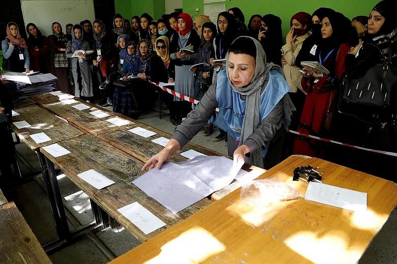 An election worker counting ballot papers at a polling station in Kabul yesterday. Initial Independent Election Commission figures showed that some three million voters turned up at 4,500 polling centres.