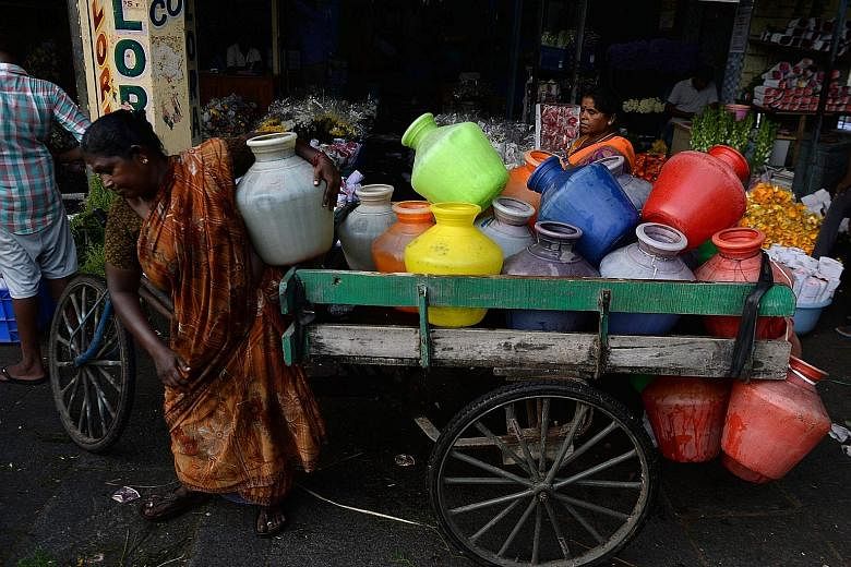 Women distributing water at a wholesale flower market during the Durga Puja festival in Chennai last week. Chennai, a coastal city in Tamil Nadu state, is situated on India's south-eastern coastline but it is not near any significant freshwater sourc
