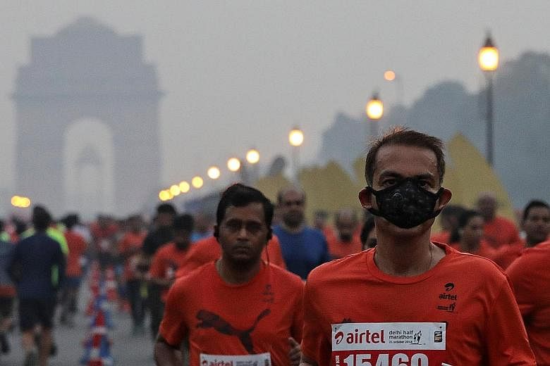A runner wearing a mask for protection from air pollution during New Delhi's half-marathon race yesterday, which was held amid a slight haze.