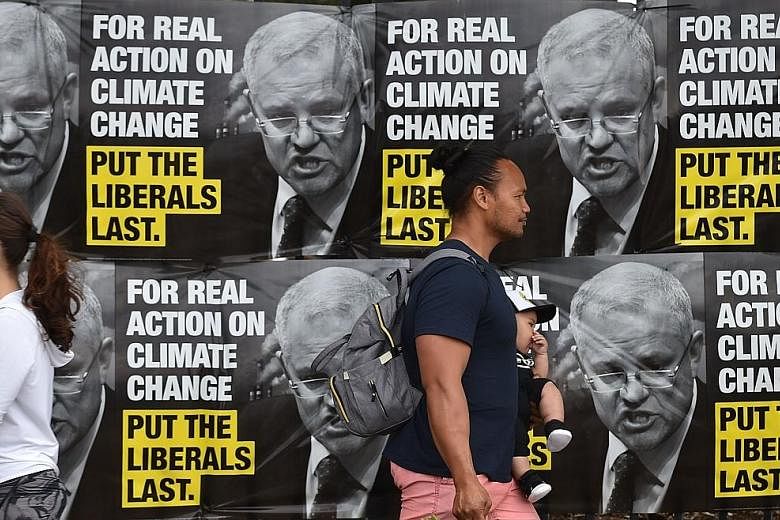 Election posters outside a polling station during the Wentworth by-election in Bondi Beach, Sydney, last Saturday. The Liberals remain deeply split on crucial issues such as climate change and immigration levels.
