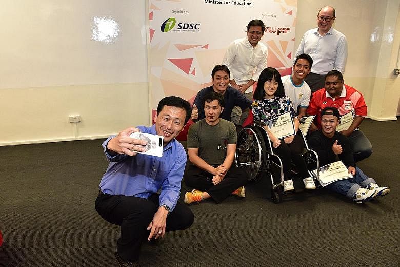Education Minister Ong Ye Kung taking a wefie with (back row, from left) Singapore Disability Sports Council (SDSC) president Kevin Wong, Haw Par Corporation chief Wee Ee Lim and six para-athletes, who were among the recipients of the inaugural Haw P