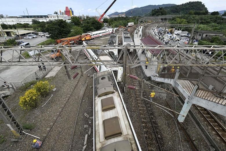 The scene of Sunday's rail disaster in Yilan, north-eastern Taiwan, which left 18 dead and 187 injured in the island's worst such incident in 27 years. All eight of the train's cars derailed, some knocking over concrete pylons.