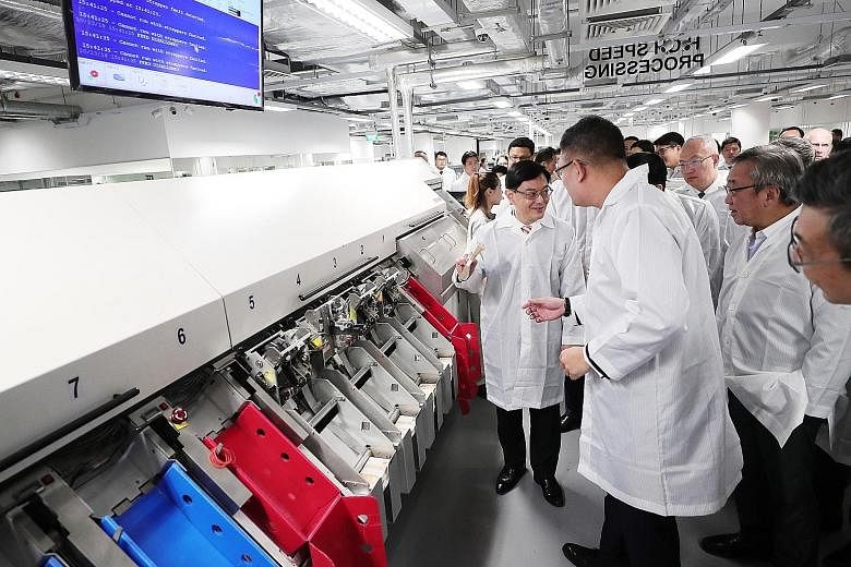 Finance Minister Heng Swee Keat visiting a cash processing centre at the new Certis Commonwealth building yesterday.