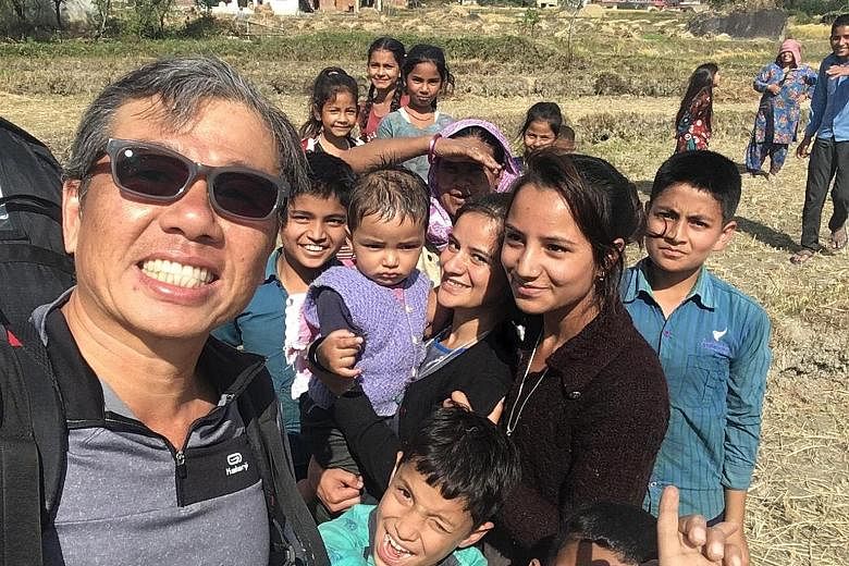 Mr Ng Kok Choong with local children in Bir Billing, India, last week after completing a flight. The day before he went missing, Mr Ng had cautioned other paragliders to be careful because of the treacherous weather conditions.