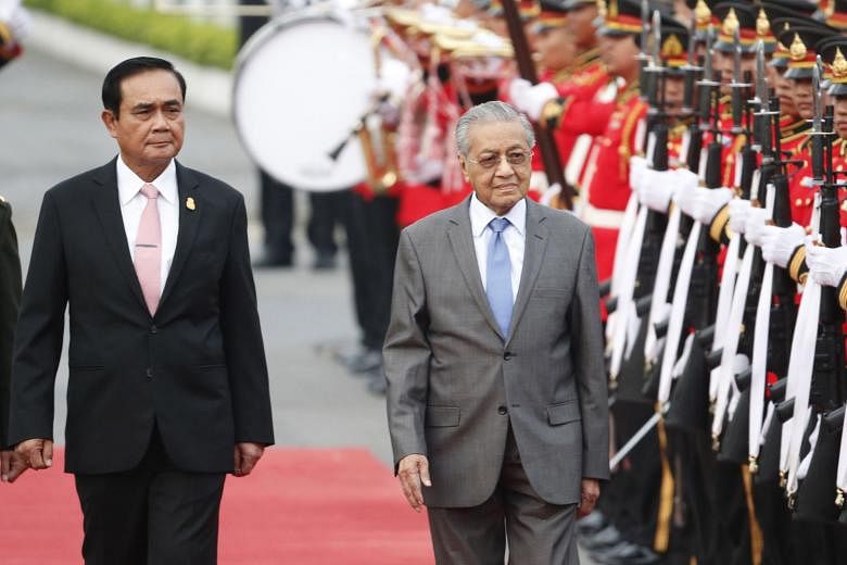 Malaysian Prime Minister Mahathir Mohamad, escorted by Thai Prime Minister Prayut Chan-o-cha, reviewing an honour guard during a welcoming ceremony yesterday at the government house in Bangkok.