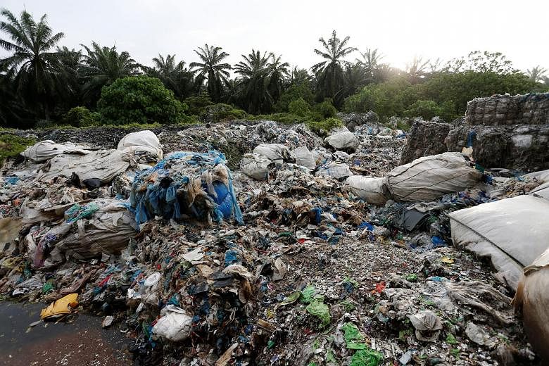 Scrap from an illegal plastic recycling factory dumped near an oil palm plantation in Jenjarom, Kuala Langat, Malaysia, last week.