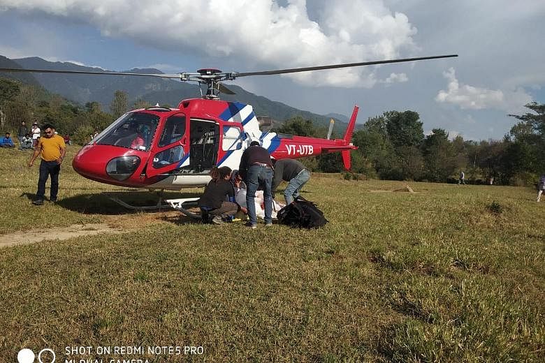 Rescuers with the body of Mr Ng Kok Choong in Bir Billing, India, on Tuesday. A post-mortem report yesterday confirmed that his death was caused by a head injury.