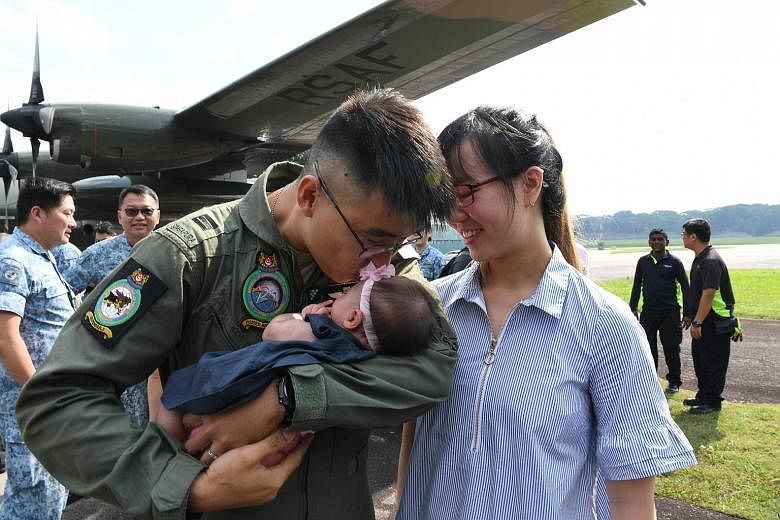 Above: Flight engineer Brian Rezel says he choked up when an elderly woman thanked him. Left: Captain Elson Wong being welcomed back by his wife, Ms Lim Yi Jie, 28, with their six-week-old baby, Amellia, at Paya Lebar Air Base. Below: Twenty-six pers