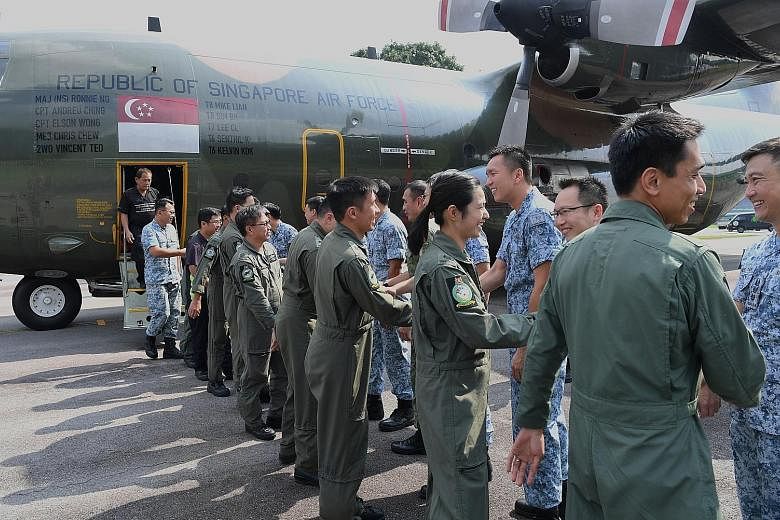 Above: Flight engineer Brian Rezel says he choked up when an elderly woman thanked him. Left: Captain Elson Wong being welcomed back by his wife, Ms Lim Yi Jie, 28, with their six-week-old baby, Amellia, at Paya Lebar Air Base. Below: Twenty-six pers