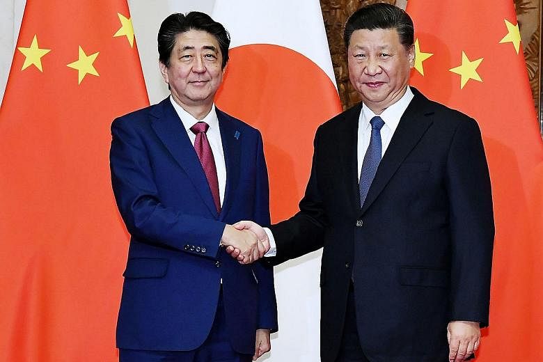 Japanese Prime Minister Shinzo Abe (left) and Chinese President Xi Jinping meeting in Beijing yesterday. A Japanese government spokesman said Mr Xi will "seriously consider" an invitation by Mr Abe to visit Tokyo.
