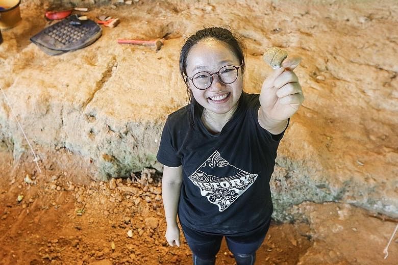 NTU student Caroline Ang, 24 (above), a history major, holding up the rare piece of Thai ceramic that she found yesterday at the Fort Canning archaeological site, where she was digging with Associate Professor Goh Geok Yian.