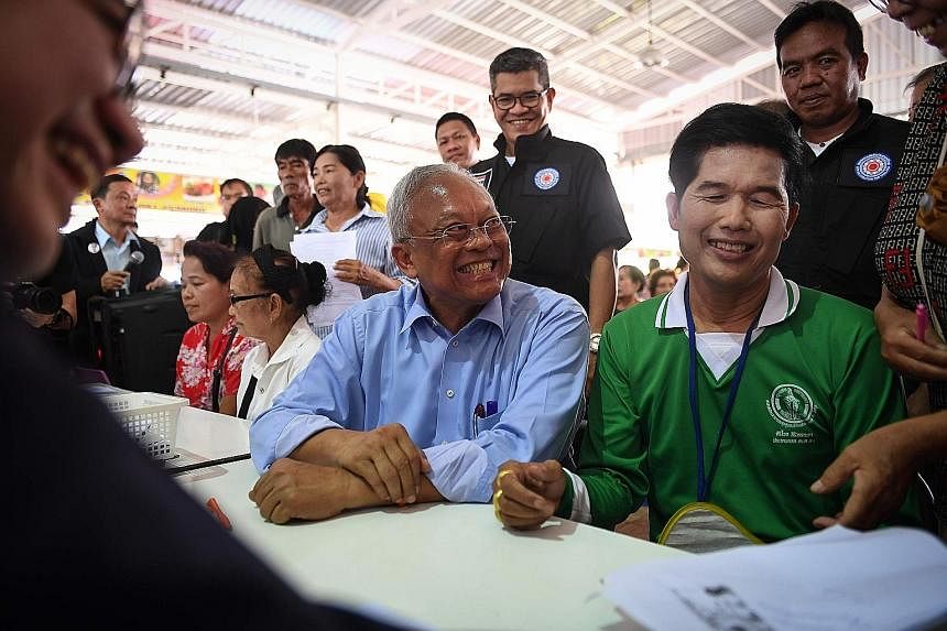 PUEA THAI Retired policeman Viroj Pao-In (centre) speaking to journalists after being named the leader of the party yesterday. ACTION COALITION FOR THAILAND Former deputy prime minister Suthep Thaugsuban (in blue shirt) helping a supporter register a