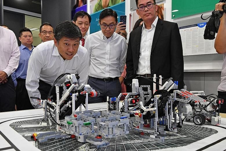 NTUC secretary-general Ng Chee Meng taking a close look at a demonstration of advanced analytics capabilities at the SAS Institute. On his left are Mr Ng Tiong Gee, president of the Tech Talent Assembly; and Mr Randy Goh (in coat), managing director 
