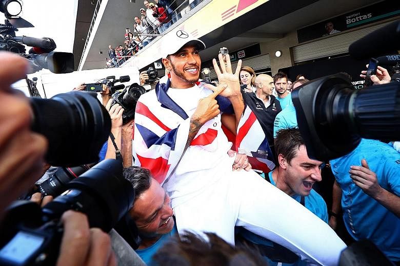 A jubilant Lewis Hamilton after wrapping up his fifth Formula One title at the Mexican Grand Prix on Sunday. He is now two titles away from matching Michael Schumacher.