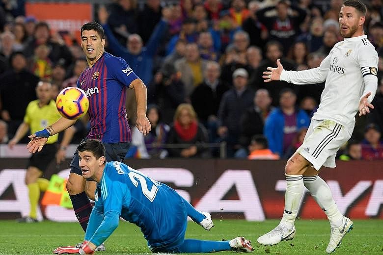 Barcelona striker Luis Suarez dinks the ball over Real Madrid custodian Thibaut Courtois to score his team's fourth goal in the 5-1 thrashing at the Nou Camp on Sunday.
