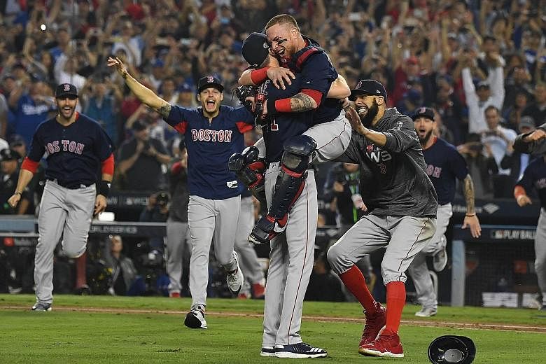 Boston Red Sox players celebrate after defeating the Los Angeles Dodgers 5-1 in Game 5 of the World Series to clinch the title. The Red Sox prevailed by a 4-1 margin in a best-of-seven series. The title triumph was Boston's fourth in 15 years, ninth 