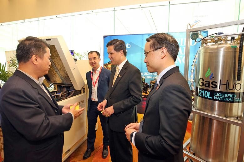Minister for Trade and Industry Chan Chun Sing (second from right) and Energy Market Authority chief executive Ngiam Shih Chun (right) viewing exhibits at the opening of Singapore International Energy Week at Marina Bay Sands yesterday.
