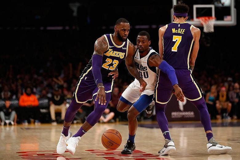 LeBron James of the Los Angeles Lakers using JaVale McGee's screen to shake off the Dallas Mavericks' Harrison Barnes at Staples Centre on Wednesday. James, who top-scored with 29 points, made a tie-breaking free throw with 2.1 seconds to go as the L