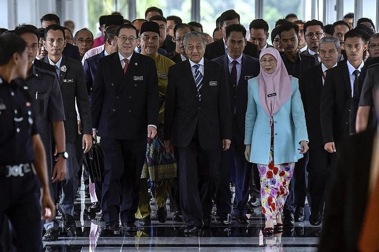 Malaysian Prime Minister Mahathir Mohamad (centre), flanked by Finance Minister Lim Guan Eng and Deputy Prime Minister Wan Azizah Wan Ismail, arriving for the budget presentation in Kuala Lumpur yesterday.