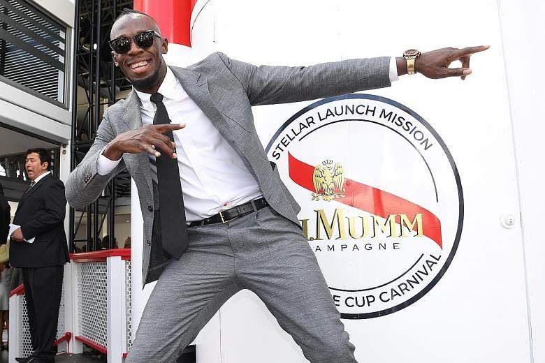 Usain Bolt striking a familiar pose at the Mumm marquee during the Victoria Derby Day, part of the Melbourne Cup Carnival, at Flemington Racecourse yesterday.