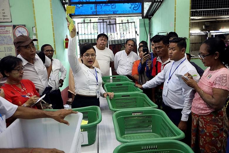 A Union Election Commission staff member counting votes at a polling station in Yangon.
