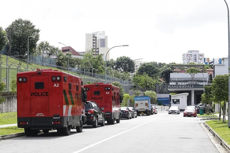 Police (above) and their vehicles (left) at the scene of the incident yesterday at Wandervale executive condominium in Choa Chu Kang. The suspect was nabbed six hours after police officers arrived at the scene.