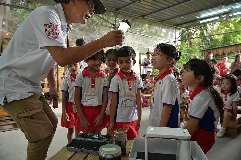 Bee Amazed Garden founder John Chong Chin Hong showing PCF Sparkletots pre-schoolers who visited his bee farm yesterday how honey is made. PCF Sparkletots has started an outdoor education programme for about 6,000 children from 73 centres for the sch
