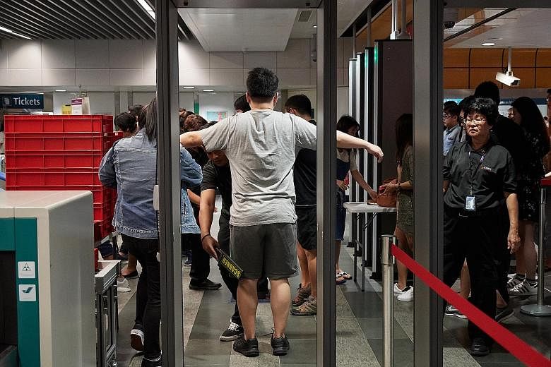 Commuters being screened during an emergency preparedness exercise at Newton MRT station in February. For its trial starting next Monday, LTA said X-ray scanners and metal detectors will be installed at selected MRT stations, and that screening equip